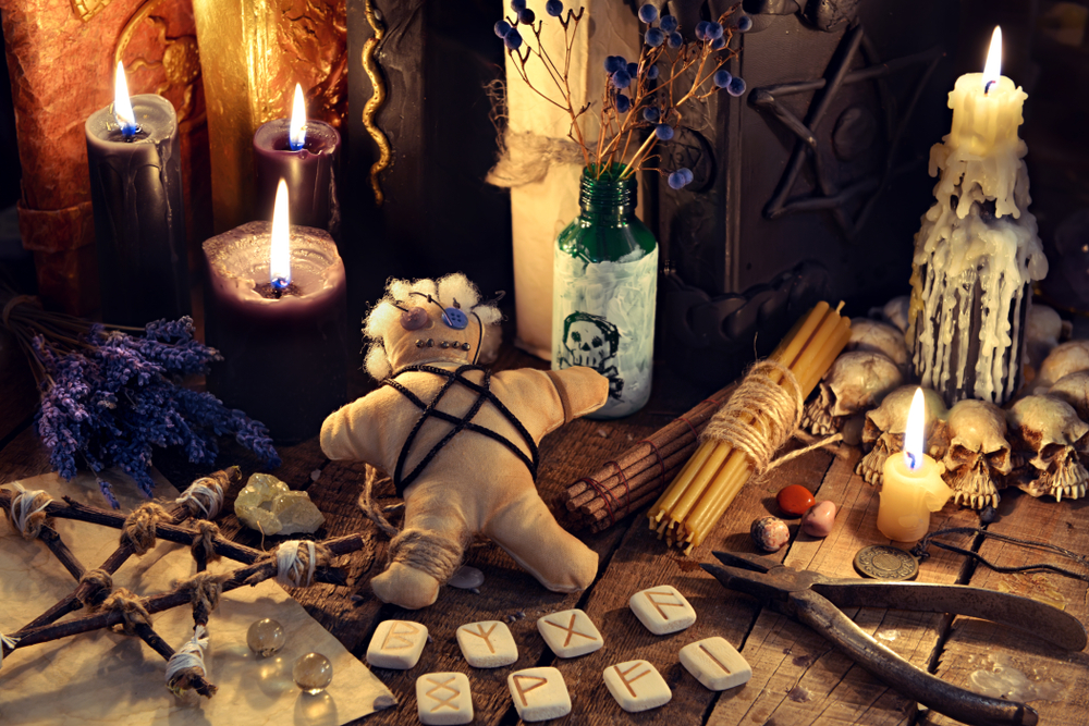 voodoo,doll,,black,candles,,pentagram,and,old,books,on,witch